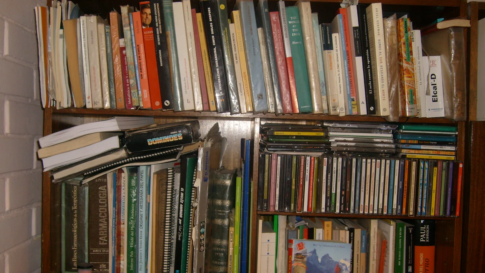 Estantería de casa abarrotada de libros, carpetas y papeles